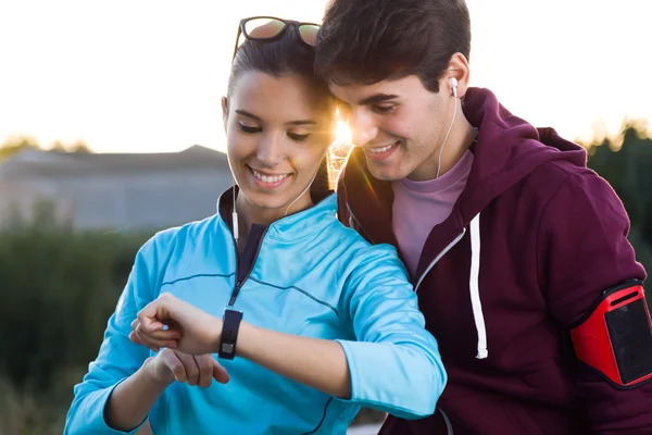 Portrét mladého páru se pomocí smartwatch po spuštění. — Stock fotografie