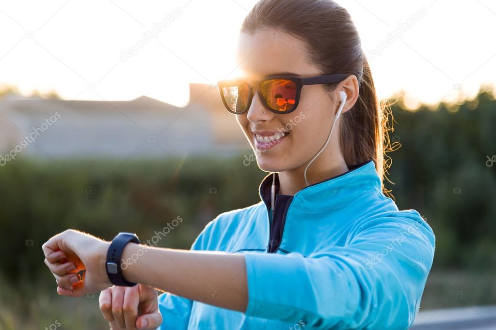 Portrait of young woman using they smartwatch after running.