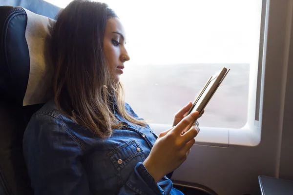 Piękna młoda kobieta, czytanie książki w pociągu. — Zdjęcie stockowe