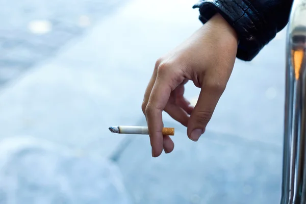 Женские руки с сигаретой на улице . — стоковое фото