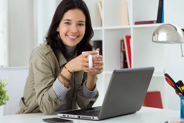 Vacker ung kvinna använder sin bärbara dator hemma. — Stockfoto