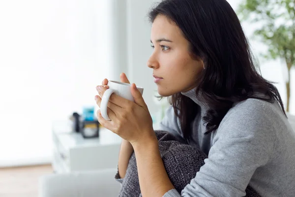 Mooie jonge vrouw drinken koffie thuis. — Stockfoto