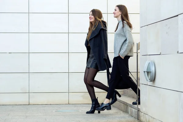 Две молодые предпринимательницы, идущие по улице рядом с офисным зданием — стоковое фото