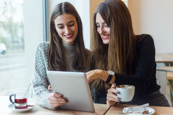 Mooie jonge vrouwen met behulp van digitale tablet in koffie winkel. — Stockfoto