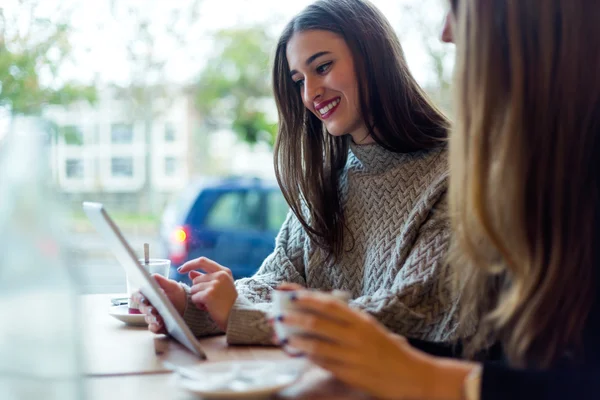 Piękne młode kobiety za pomocą cyfrowego tabletu w kawiarni. — Zdjęcie stockowe