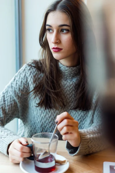 Beautiful young woman drinking tea in a coffee shop. — Stock Photo, Image