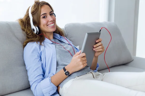 Schöne junge Frau hört Musik mit digitalem Tablet bei — Stockfoto