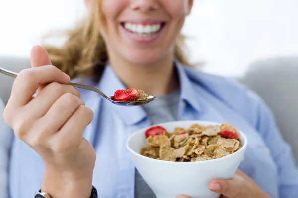 Vacker ung kvinna äta spannmål hemma. — Stockfoto