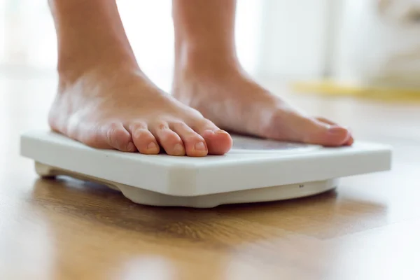 Young healthy girl on home scales. — Stock Photo, Image