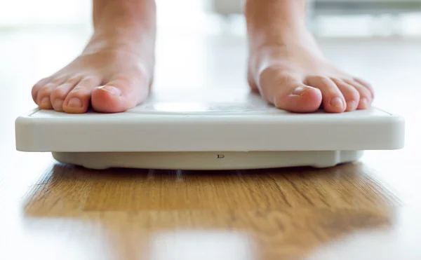 Young healthy girl on home scales. — Stock Photo, Image