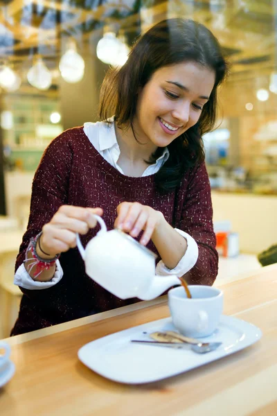 Mooie jonge vrouw drinken koffie bij café shop. — Stockfoto