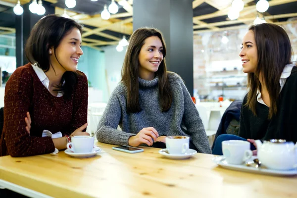 Three young beautiful women drinking coffee at cafe shop. — Stock Photo, Image
