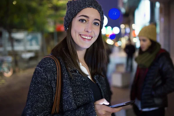 Portret van mooie jonge vrouw met behulp van haar mobiele telefoon bij nigh — Stockfoto