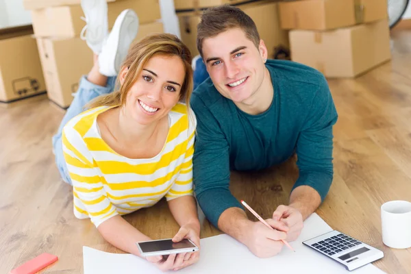 Jeune couple avec tablette numérique dans leur nouvelle maison — Photo