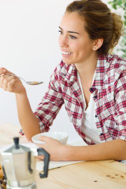 Yeni evinde kahvaltı keyfi güzel genç kadın.