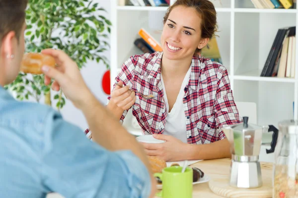 Mooie jonge paar genieten van ontbijt in hun nieuwe huis. — Stockfoto