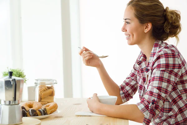 Vacker ung kvinna njuter av frukost i sitt nya hem. — Stockfoto