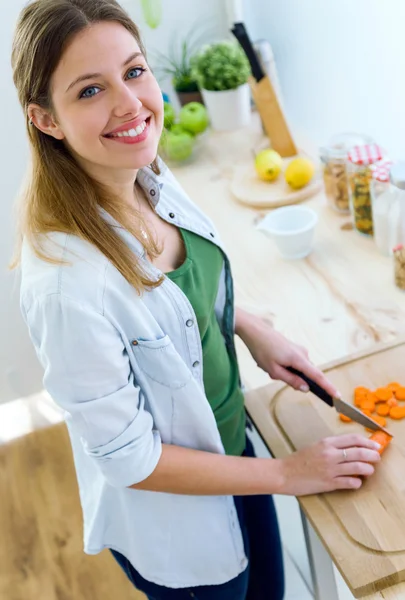 Mujer bastante joven cortando verduras en la cocina . — Foto de Stock