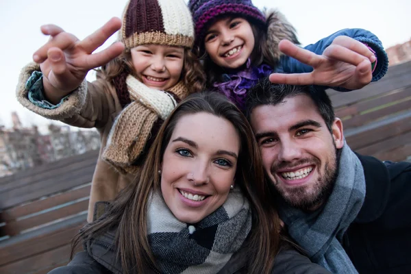 Jovem família feliz tirando uma selfie na rua . — Fotografia de Stock