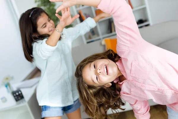 Dos hermanas jóvenes escuchando música y bailando en casa . — Foto de Stock