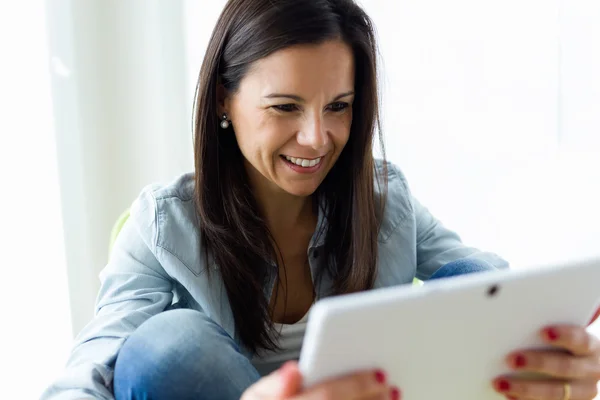 Vacker ung kvinna med sin digitala tablett hemma. — Stockfoto