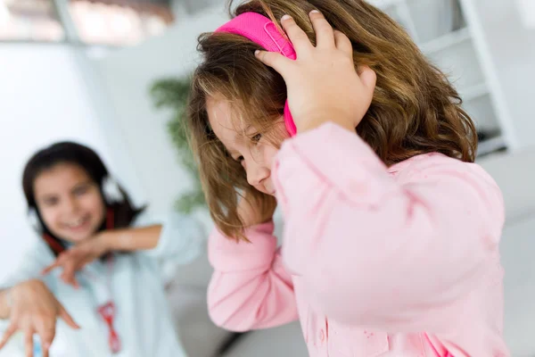 Dos hermanas jóvenes escuchando música y bailando en casa . — Foto de Stock