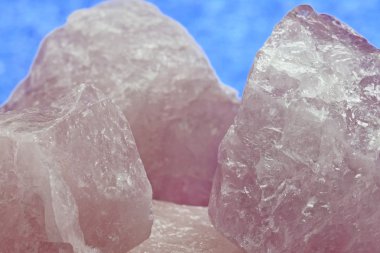 Rose kuvars bir parça huzur mavi bir arka plan karşı yakın. Rose kuvars (pembe) ve huzur (mavi renkler yıl kavramının-).