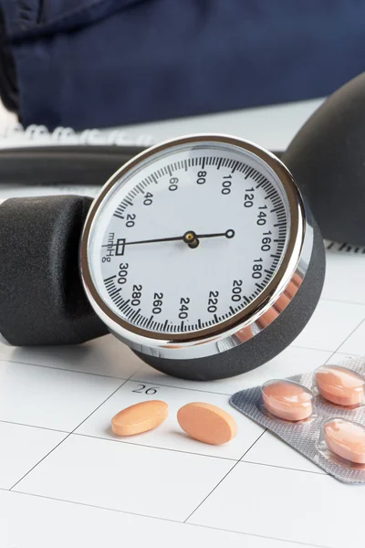 Tablets and Blood Pressure Meter on a Calendar — Stock Photo, Image