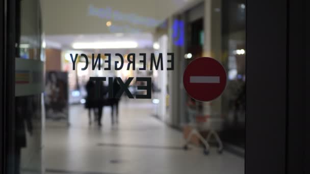 Señal de salida de emergencia en un centro comercial vacío durante una pandemia — Vídeo de stock