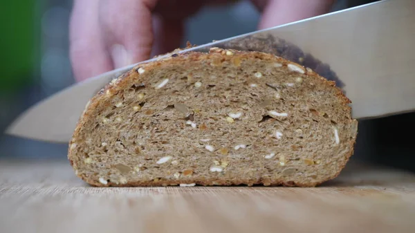 Slicing Whole Grain Bread On Wooden Table