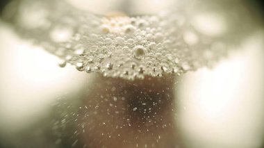 Sıvı bir makro çekim sahasının yüzeysel derinliğinde kabarcıklar