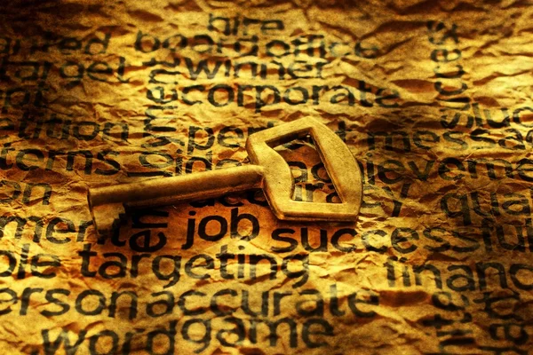 Golden key on job text grunge concept — Stock Photo, Image