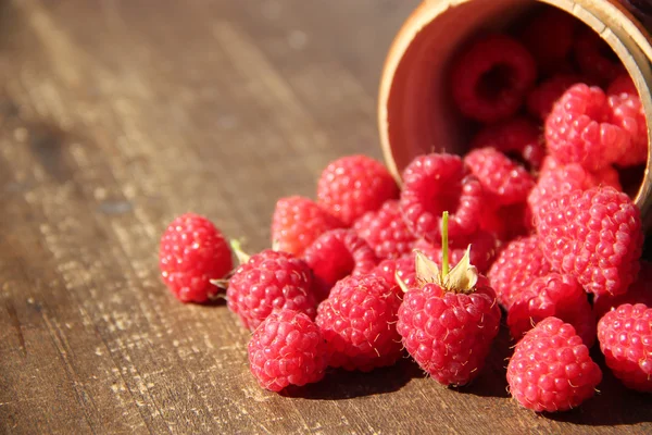 Reife süße Himbeeren in Schüssel auf Holztisch — Stockfoto