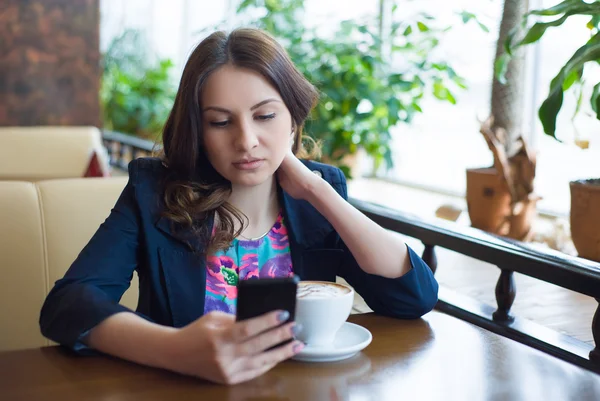 Güzel genç kız kahve içiyor.