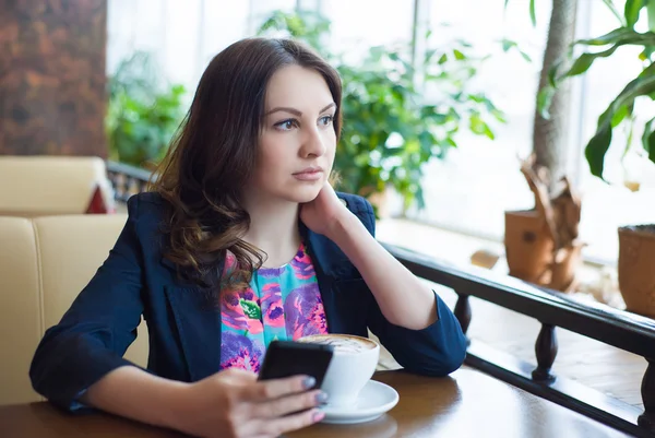 Güzel genç kız kahve içiyor.