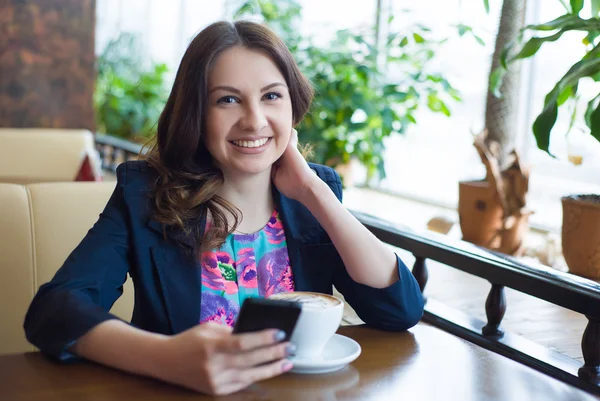 Güzel genç kız kahve içiyor.