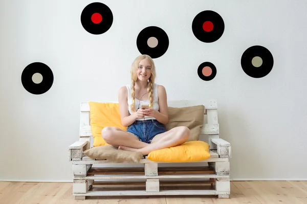 Bella ragazza ascoltando musica a casa seduta sul c — Foto Stock