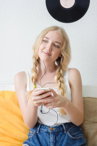 Hermosa joven escuchando música en casa sentado en la c — Foto de Stock