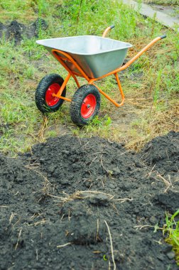 Bir el arabası bahçede, eser toprak taşınan