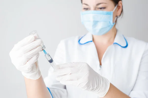 Kız, sağlık çalışanı aşı bir şırınga çevirir