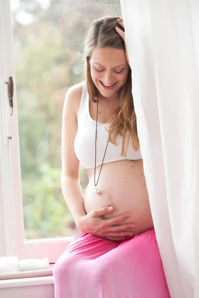 Gravid kvinna i hennes fönster — Stockfoto