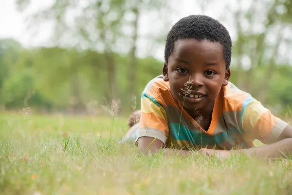 Afrikaanse jongen in het gras — Stockfoto