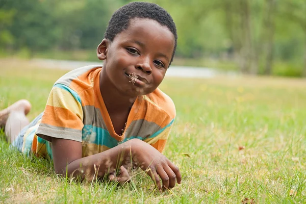Afrikansk pojke äter gräs — Stockfoto