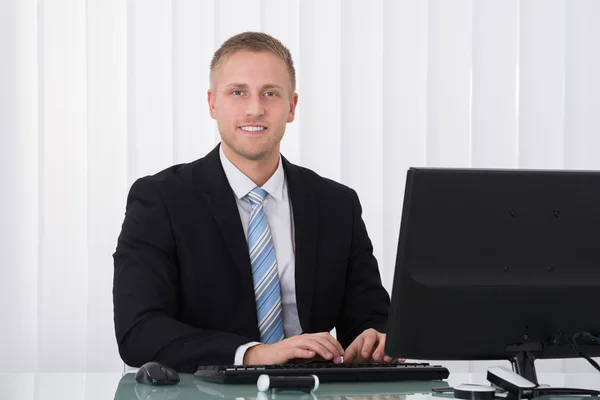 Lächelnder junger Geschäftsmann im Büro — Stockfoto