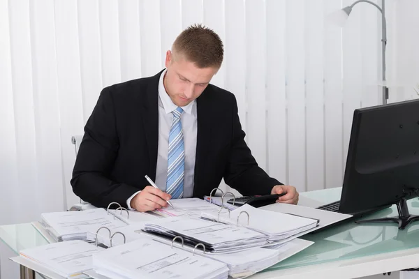 Empresario examinando facturaEn la oficina — Foto de Stock