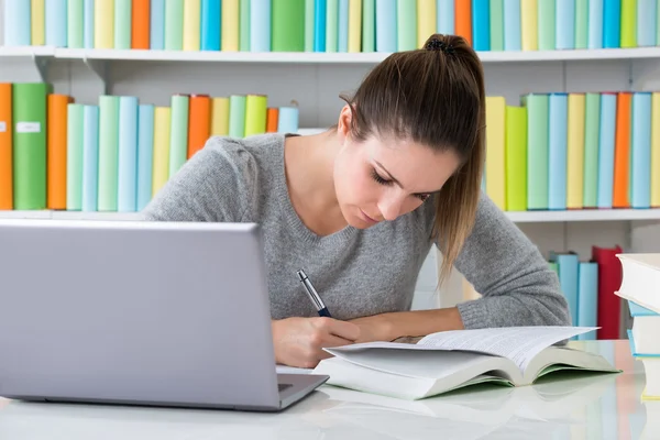 Mulher estudando na biblioteca — Fotografia de Stock