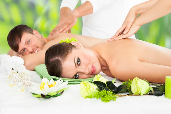 Lächelndes Paar erhält Rückenmassage im Wellnessbereich — Stockfoto