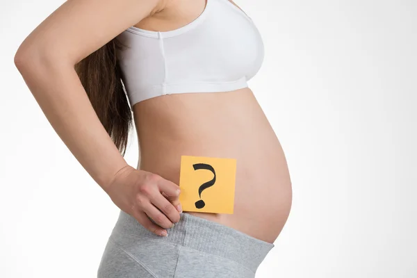 Femme enceinte avec un point d'interrogation sur papier — Photo