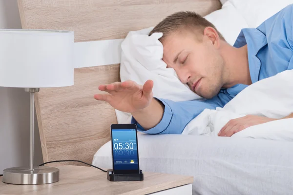 Man liggen in bed en Snoozing Mobile — Stockfoto