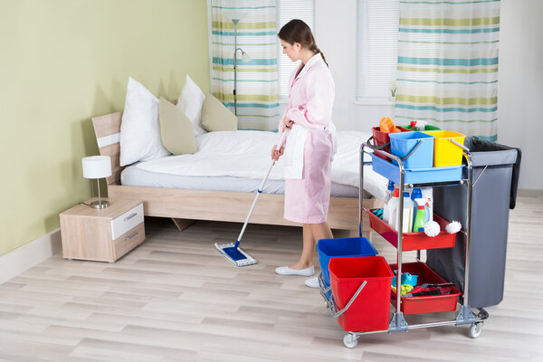 Housekeeper Mopping Floor In Room
